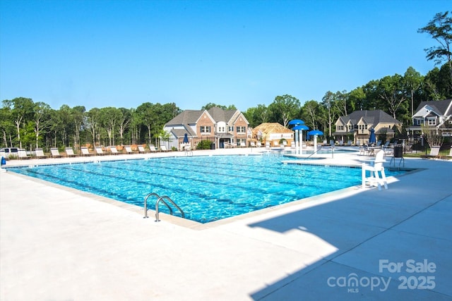 pool with a patio area and fence