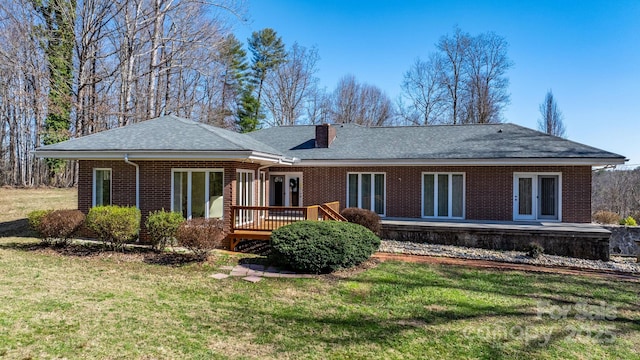 back of house featuring french doors, brick siding, a chimney, and a wooden deck