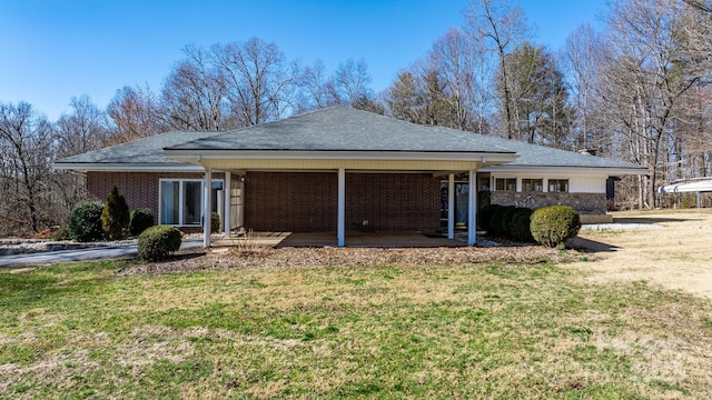 exterior space with brick siding and a yard