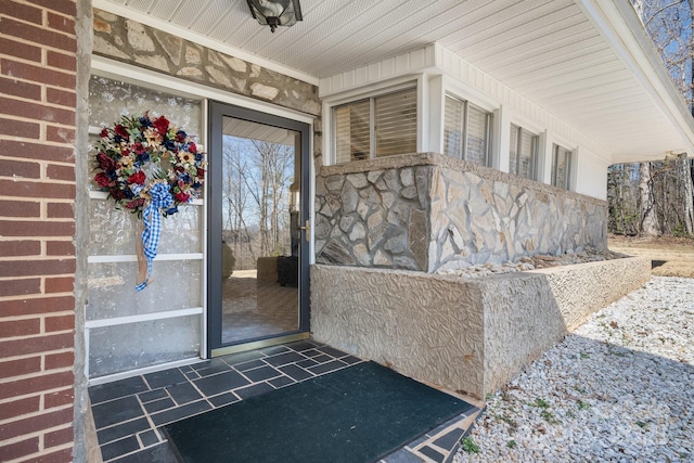 doorway to property featuring brick siding