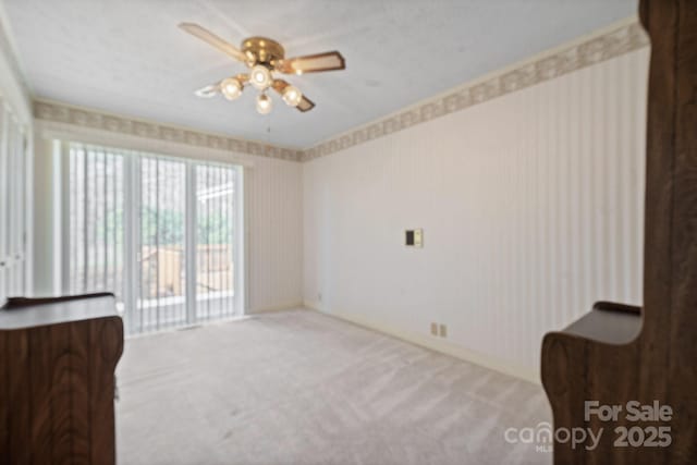 interior space with light colored carpet, ceiling fan, and wallpapered walls