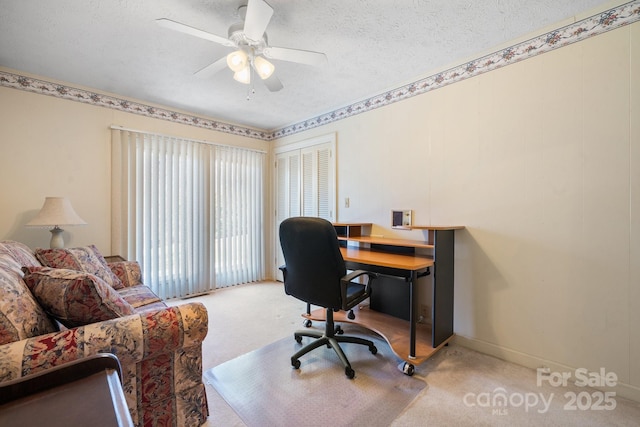 office area with a ceiling fan, light carpet, a textured ceiling, and baseboards