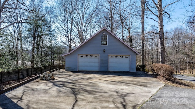 detached garage featuring fence