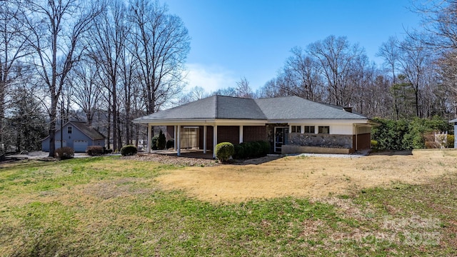 rear view of property with covered porch and a yard