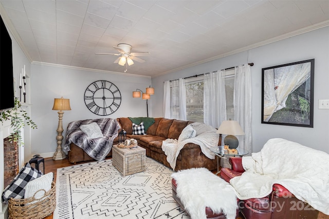 living room featuring a ceiling fan, crown molding, baseboards, and wood finished floors