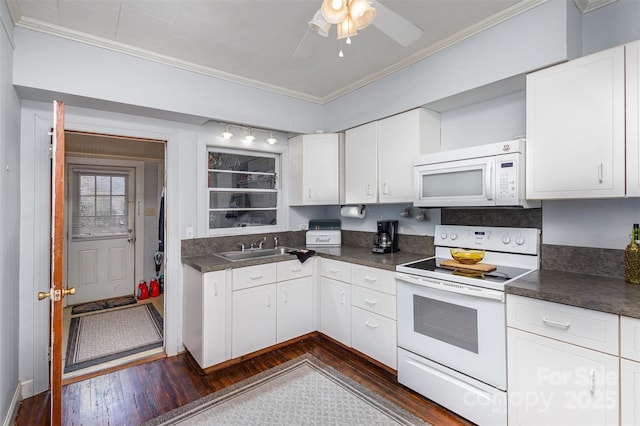 kitchen featuring dark wood finished floors, dark countertops, ornamental molding, a sink, and white appliances