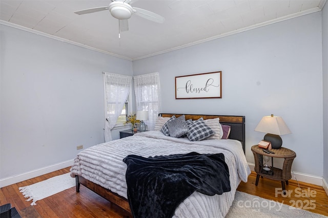 bedroom with ornamental molding, a ceiling fan, baseboards, and wood finished floors