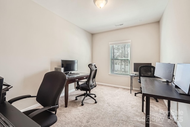 office area with light colored carpet, visible vents, and baseboards