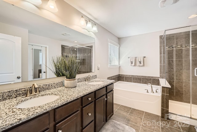 bathroom featuring a stall shower, tile patterned flooring, a sink, and a bath