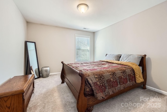 bedroom with baseboards, visible vents, and light colored carpet