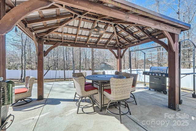 view of patio featuring outdoor dining area, a grill, fence, and a gazebo