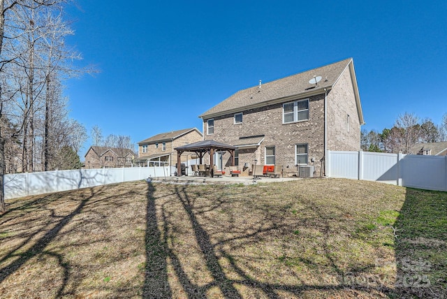 back of house featuring a fenced backyard, a patio, a gazebo, and a lawn