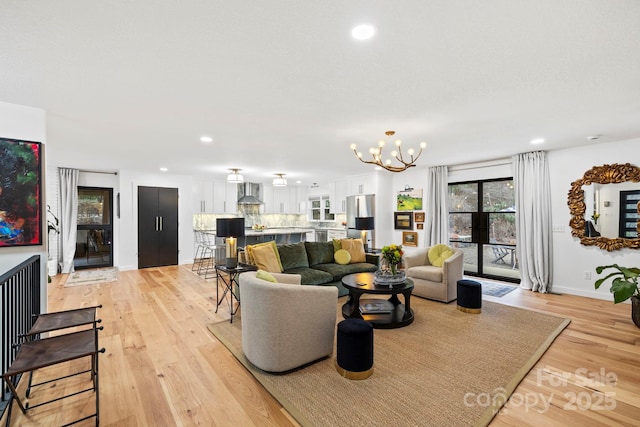 living area featuring light wood-style flooring, a chandelier, baseboards, and recessed lighting