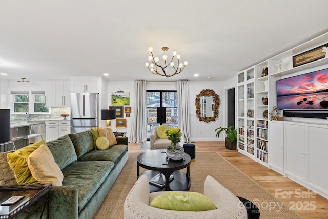 living room featuring a chandelier, light wood finished floors, recessed lighting, and a healthy amount of sunlight