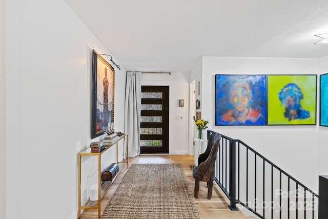 foyer entrance with wood finished floors and baseboards