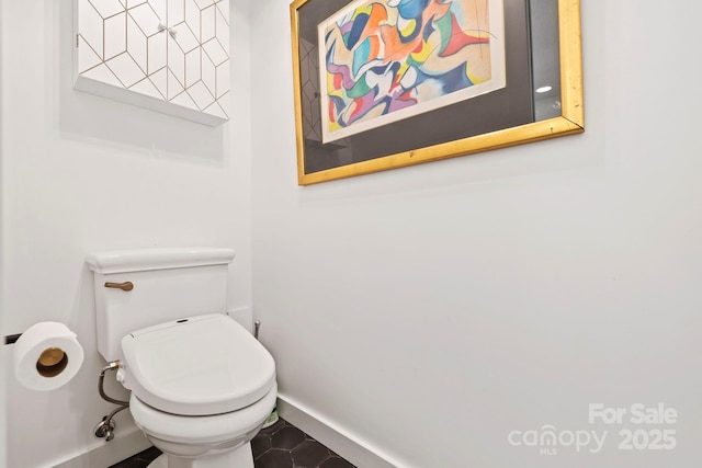 bathroom featuring baseboards and toilet