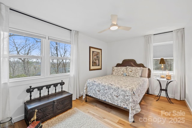 bedroom featuring light wood-style floors, baseboards, and a ceiling fan