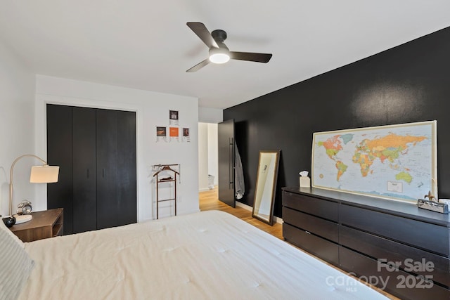 bedroom featuring light wood finished floors, ceiling fan, and a closet