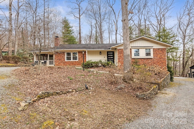 single story home with brick siding, a chimney, and a porch