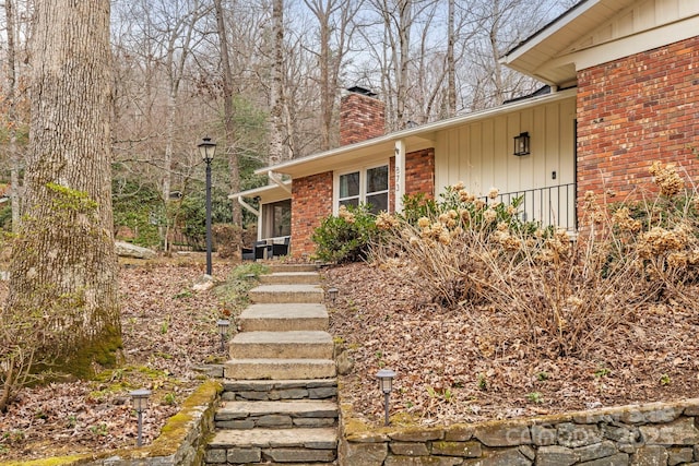 view of front of property featuring brick siding and a chimney