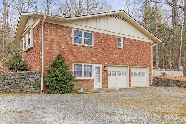 view of home's exterior with driveway, brick siding, and an attached garage