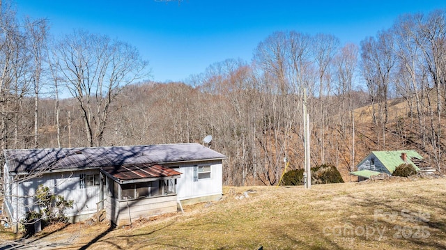 rear view of house featuring a forest view