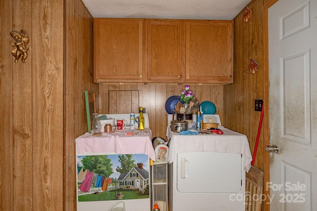 laundry area featuring washer / dryer and wooden walls