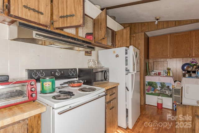 kitchen featuring white appliances, brown cabinets, light countertops, under cabinet range hood, and backsplash