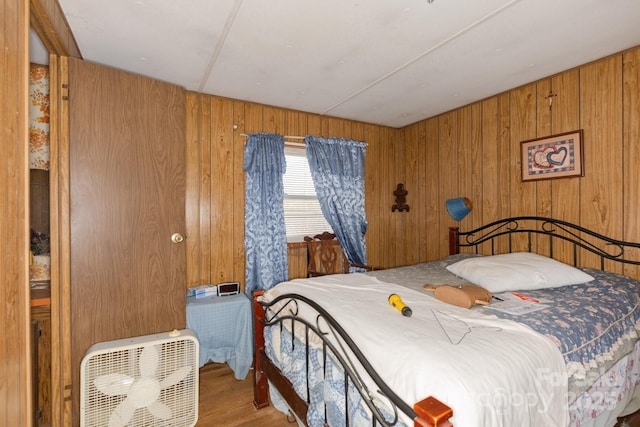 bedroom with wooden walls and wood finished floors