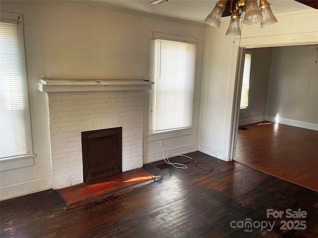 unfurnished living room featuring a fireplace, wood finished floors, a ceiling fan, baseboards, and ornamental molding