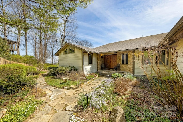 exterior space featuring roof with shingles