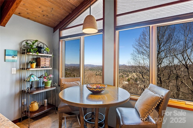 dining room featuring a mountain view, wooden ceiling, and lofted ceiling