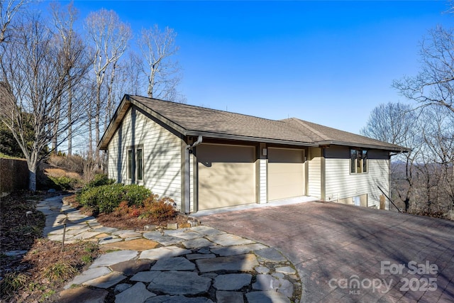 view of home's exterior with driveway and a shingled roof