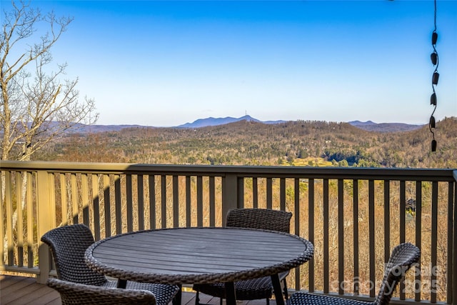 wooden terrace with a mountain view and outdoor dining area