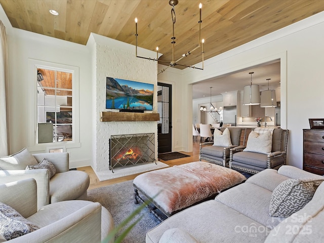 living room with wooden ceiling, light wood-style floors, a fireplace, a chandelier, and recessed lighting