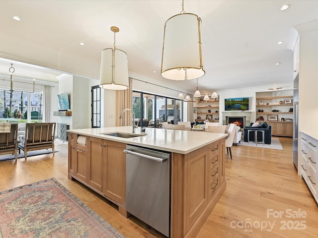 kitchen featuring open floor plan, light countertops, dishwasher, and decorative light fixtures