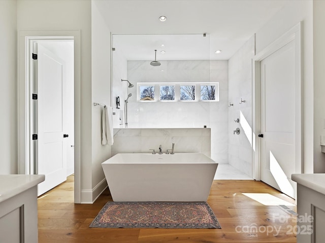 full bathroom featuring hardwood / wood-style flooring, a soaking tub, walk in shower, vanity, and recessed lighting