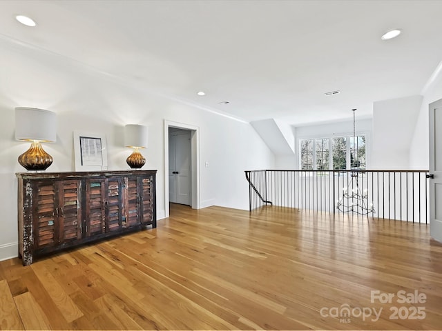 spare room with light wood-type flooring, baseboards, a notable chandelier, and recessed lighting