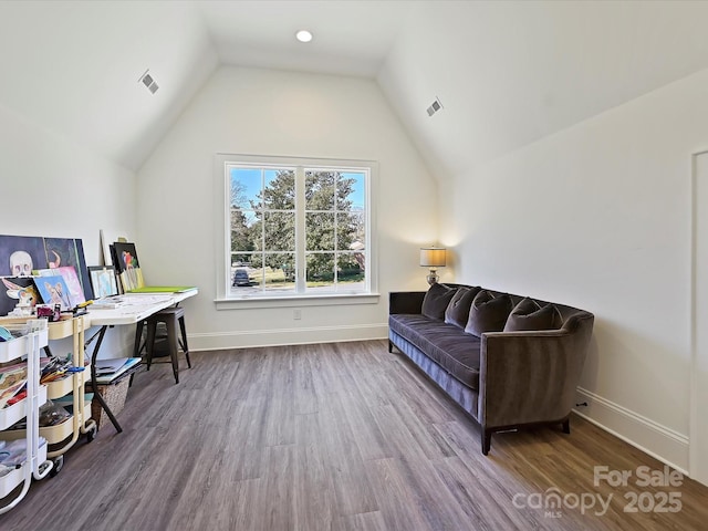 office area featuring lofted ceiling, wood finished floors, visible vents, and baseboards