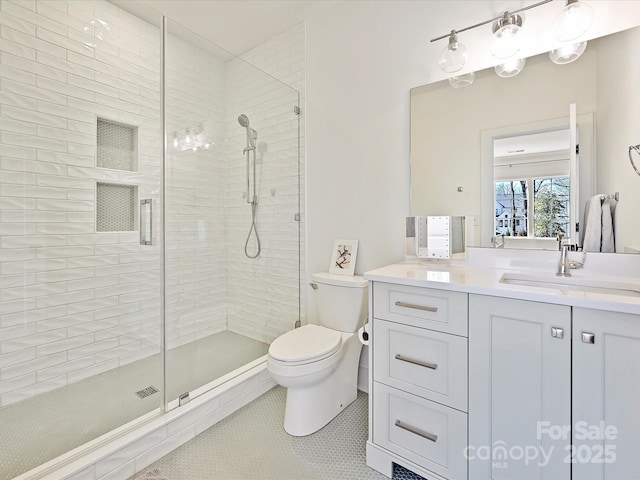 full bath with toilet, a stall shower, tile patterned floors, and vanity