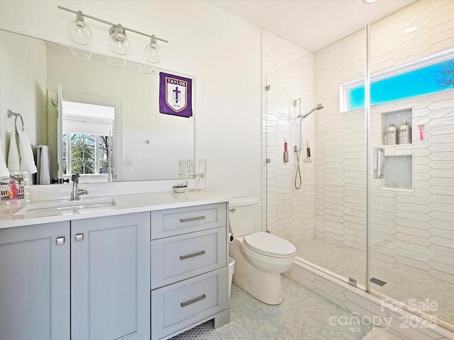 bathroom featuring toilet, tile patterned floors, a shower stall, and vanity