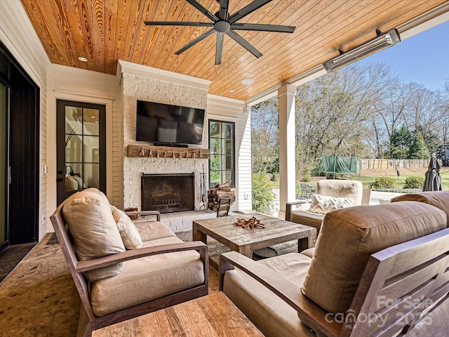 view of patio / terrace featuring an outdoor living space with a fireplace, fence, and a ceiling fan