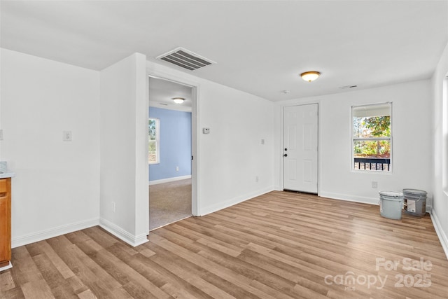 interior space with light wood finished floors, visible vents, and baseboards