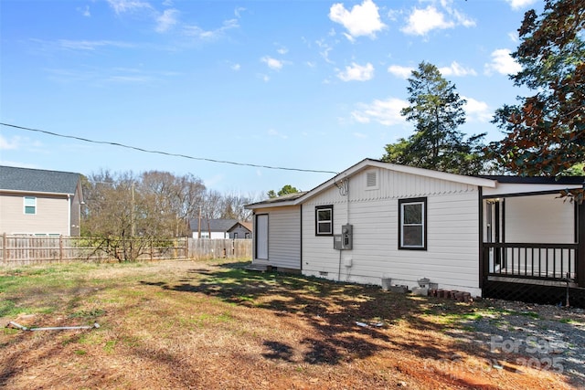 view of side of home featuring crawl space, fence, and a lawn