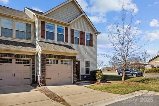 multi unit property featuring a garage and driveway