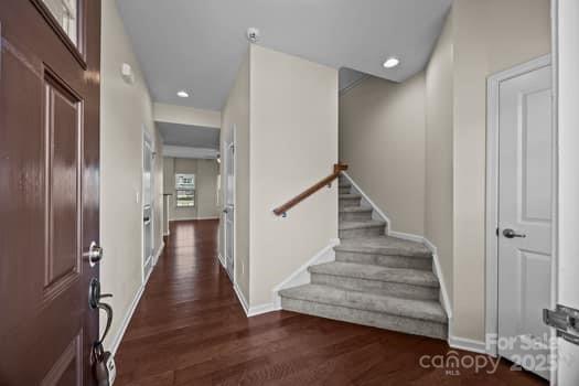 foyer entrance with stairs, baseboards, wood finished floors, and recessed lighting