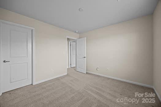 unfurnished bedroom featuring carpet floors and baseboards