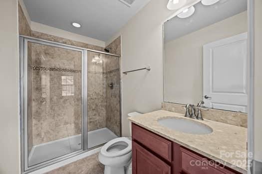 full bath featuring visible vents, a stall shower, vanity, and toilet