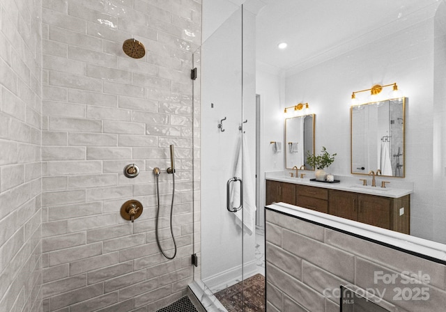 bathroom with recessed lighting, a sink, ornamental molding, tiled shower, and double vanity