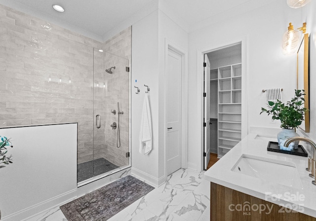 bathroom with double vanity, baseboards, marble finish floor, a shower stall, and a sink